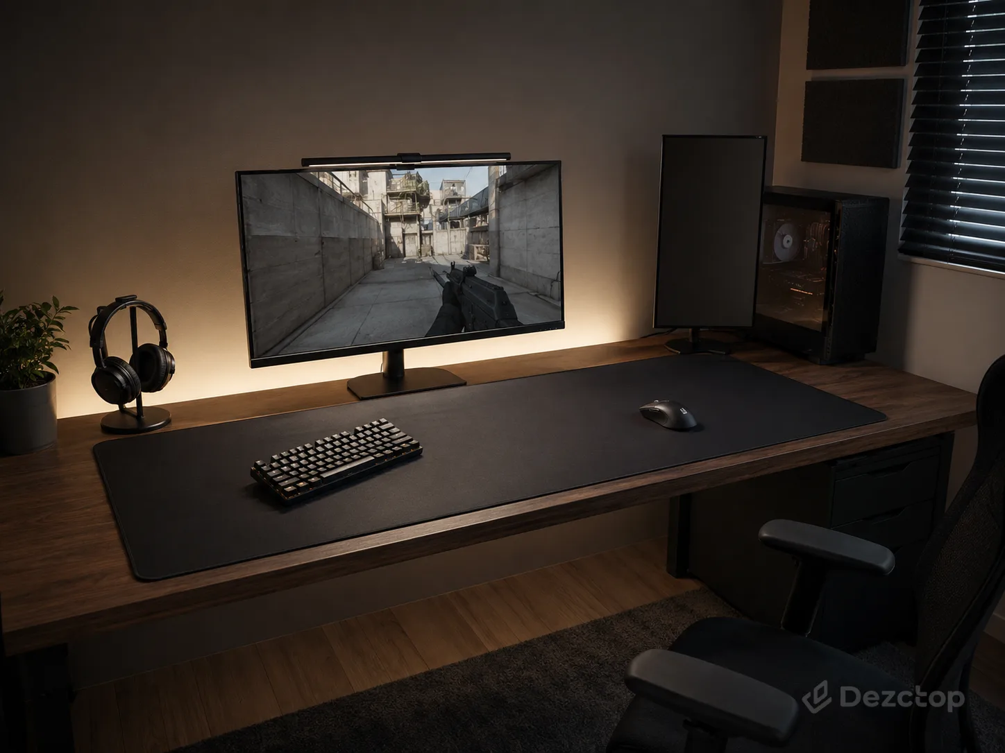 Competitive FPS gaming setup with a centered ultrawide monitor, tenkeyless keyboard, and oversized desk mat for wide mouse movements.