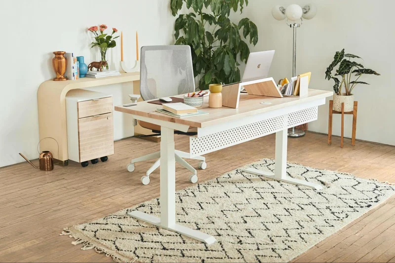 Image of a laptop on a white standing desk.