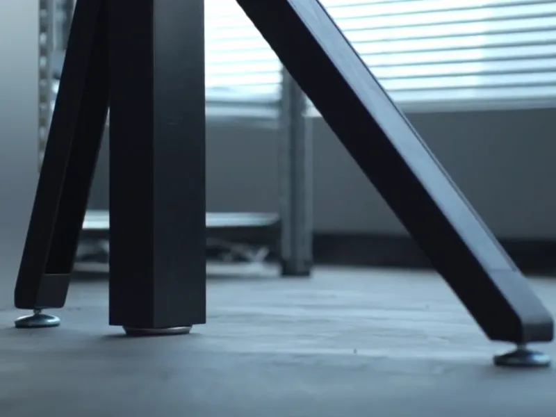 Close-up view of Revon standing desk’s adjustable leveling feet ensuring stability on uneven floors.