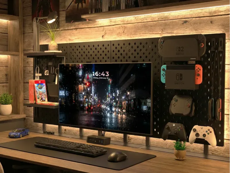 Bifrost桌搭配黑色洞洞板，掛載Switch遊戲主機、手把與周邊配件，螢幕顯示夜景畫面