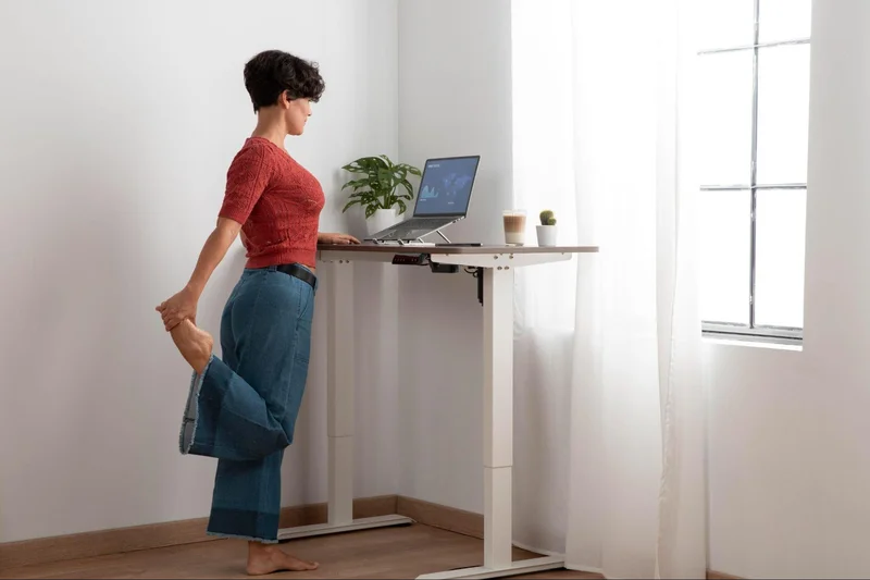 Picture of a person practicing healthy back habits by using a standing desk, emphasizing workplace wellness and office ergonomics.