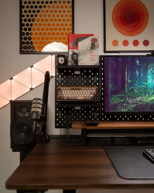 D-Board desk storage setup with shelves, books, keyboard display, monitor, speaker, and wall art in a modern workspace. D-Board desk storage setup with shelves, books, keyboard display, monitor, speaker, and wall art in a modern workspace.