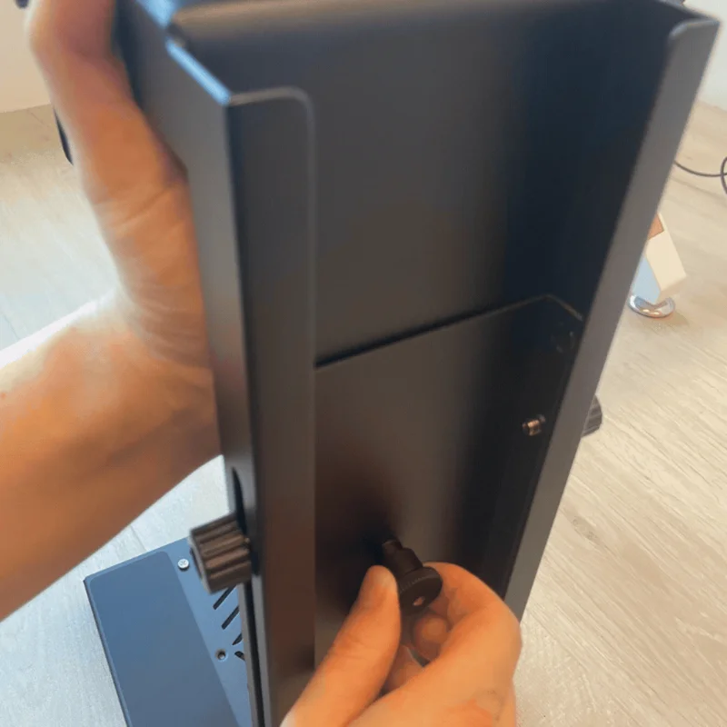 Pulling up the spring pin on the back of the PC mount to adjust the telescopic support height